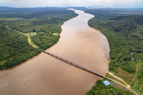 un fleuve dans la jungle avec un pont en Guyane