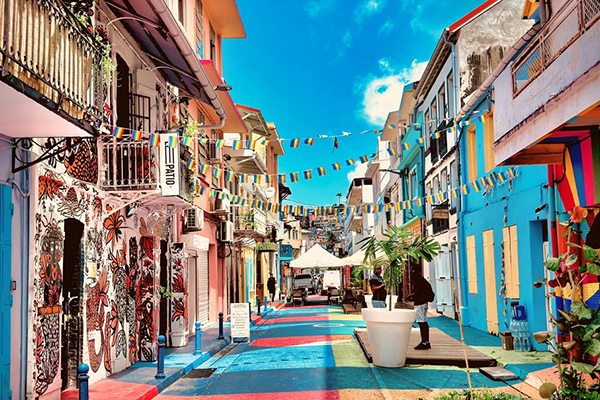 Rue piétonne animée et colorée à Fort-de-France, Martinique, ornée de guirlandes de fanions et de fresques murales artistique