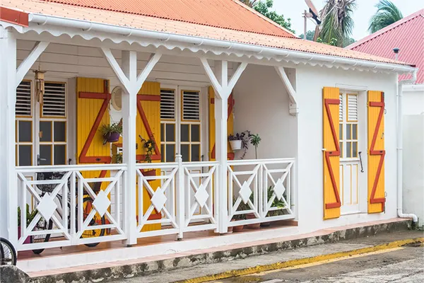 Authentique maison créole traditionnelle en Guadeloupe, avec sa galerie et ses volets colorés. Ce type d'hébergement off