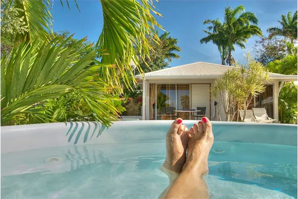 Détente dans un jacuzzi privé au milieu du jardin tropical. Ce type d'hébergement (villa ou bungalow moderne) est idéal 
