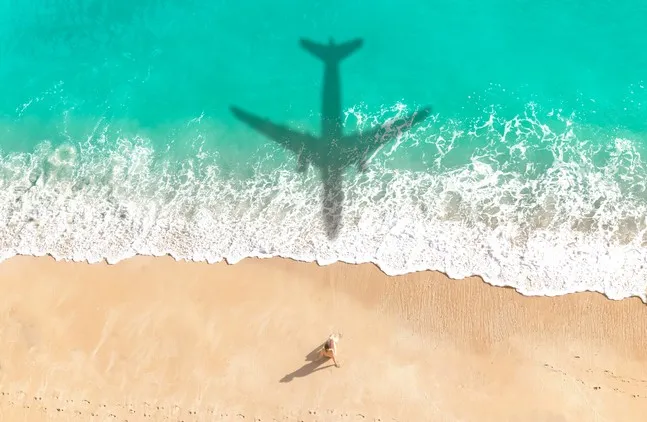 Un avion survolant une plage