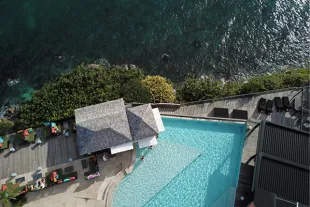 Vue aérienne spectaculaire de la piscine à débordement de La Toubana Hôtel & Spa, premier établissement 5 étoiles de Guadeloupe, surplombant l'océan et ses eaux turquoise.