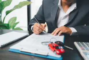 Signature d'un contrat de location de voiture à l'aéroport Aimé Césaire en Martinique. Étape clé pour vérifier les assurances et la caution avant de partir explorer l'île.