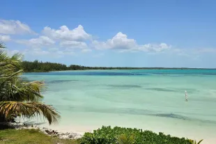 Plage de sable blanc sous un ciel bleu aux Bahamas