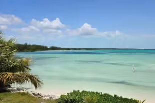 Plage de sable blanc sous un ciel bleu aux Bahamas